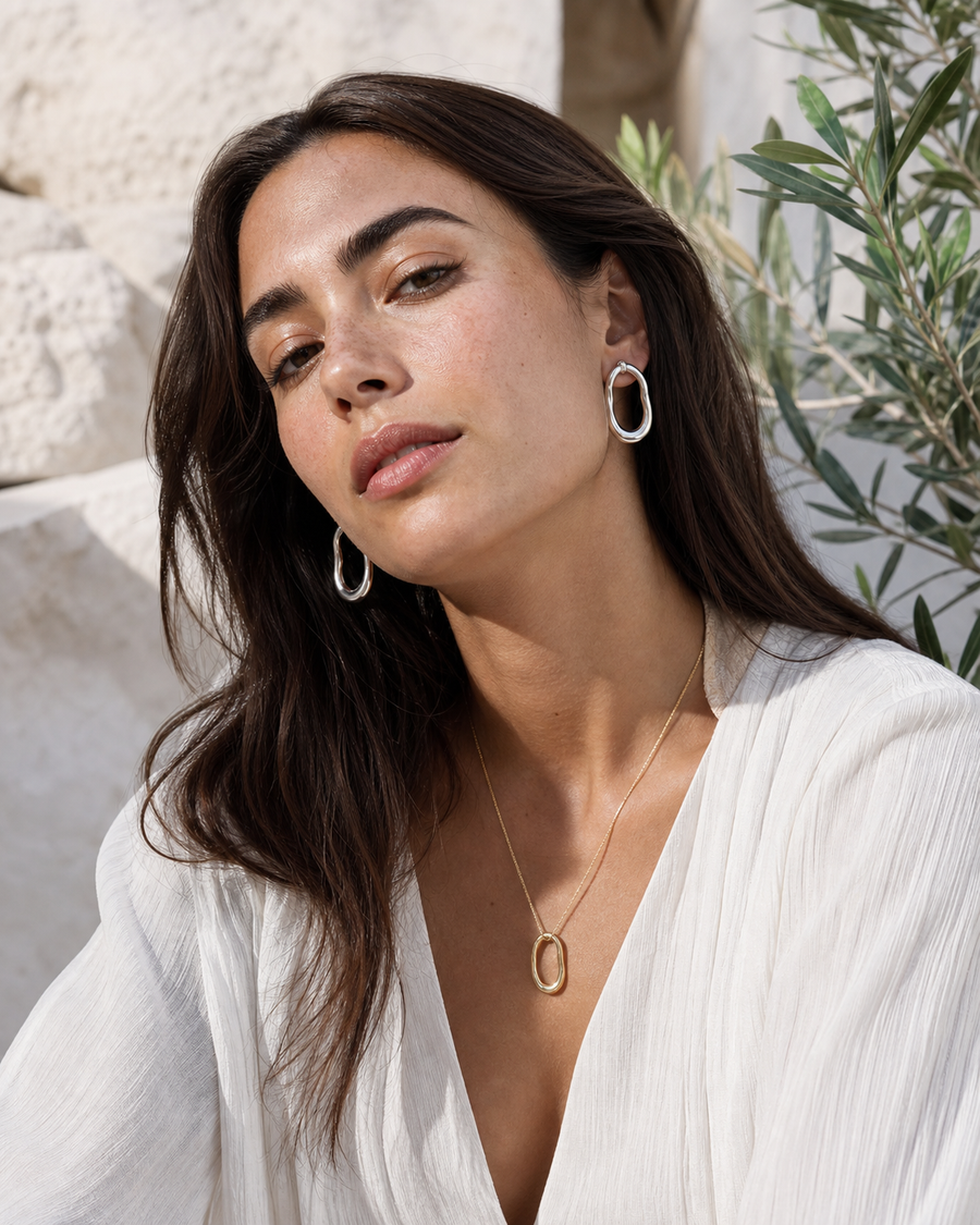 Model in natural light wearing Rare Matters earrings and pendant necklace