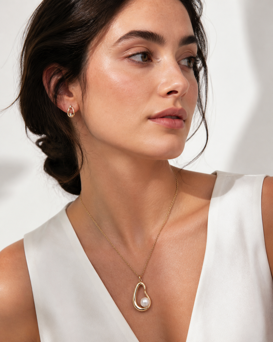 Model wearing a Rare Matters pearl pendant necklace and pearl earrings